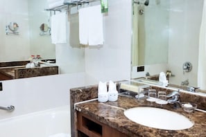 A bathroom with a marble sink, a large mirror, and a glass shower enclosure. - Jinling Danyang Hotel (Danyang)