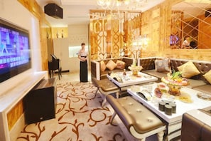 A spacious living room with a large flat-screen TV, comfortable seating, and a decorative chandelier. - Jinling Danyang Hotel (Danyang)