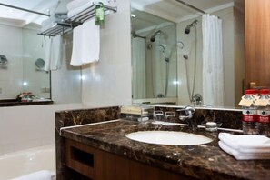 A modern bathroom with a marble sink, a large mirror, a glass-enclosed shower, and a towel rack. - Jinling Danyang Hotel (Danyang)