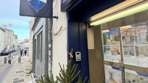 A RE/MAX real estate office with a display window showcasing property listings.