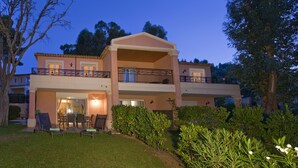 A two-story building with a balcony and outdoor seating area. - 4 bed sleeps 8  beach front villa with Shared Pool and Private Garden. (Roquebrune-Sur-Argens)