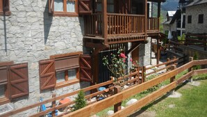 A traditional chalet with wooden balconies, stone walls, and a wooden fence. - Magic Pirineos, Apartment in Linsoles, Valle de Benasque with Pool and WIFI  (Anciles)