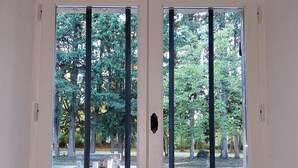 A room with a large window overlooking a park with trees and a bench. - Shed the heart of Provence (Saint-Rémy-De-Provence)