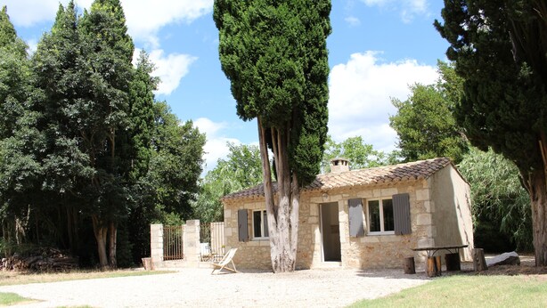 A stone building with a tiled roof, surrounded by trees and a grassy area. - Shed the heart of Provence (Saint-Rémy-De-Provence)