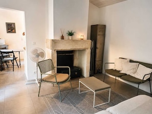 A living room with a fireplace, a dining area, and a sofa. - Shed the heart of Provence (Saint-Rémy-De-Provence)