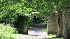 A rural pathway leading through a stone archway surrounded by lush greenery. - Spacious and luxurious, Barnton - Cramond, Edinburgh - near golf, city, sea  (Edinburgh)