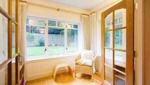 A room with a large window, a wicker chair, and a wooden floor. - Spacious and luxurious, Barnton - Cramond, Edinburgh - near golf, city, sea  (Edinburgh)
