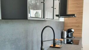 A modern kitchen with a stainless steel sink, a black faucet, and a coffee maker on the counter. - Holiday Home Sciacca (San Giorgio)