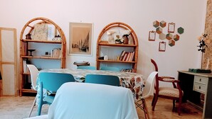 A room with a dining table, chairs, a bookshelf, a desk, and a chair. - Sanremo, apartment with parking, air conditioning, near the beaches (Sanremo)
