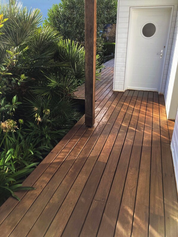 A wooden deck with a white door and a small window.