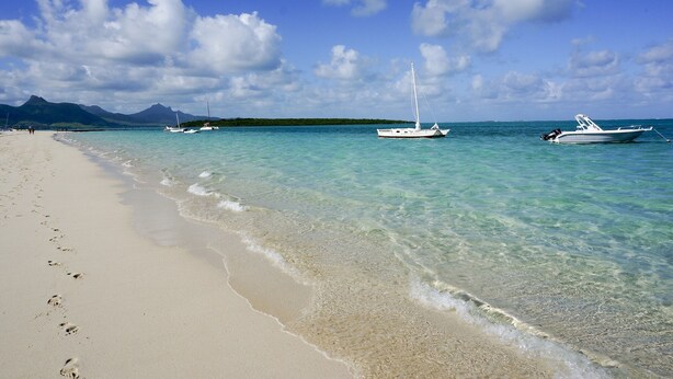 A beach with clear turquoise water, white boats, and a mountain in the background. - Pointe D Esny: House / Villa - Pointe d''Esny (Pointe d'Esny)