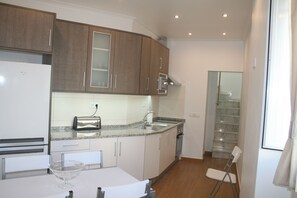 A modern kitchen with granite countertops, stainless steel appliances, and wooden cabinets.