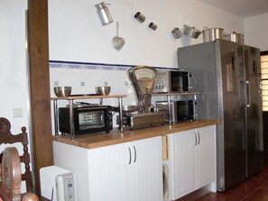 A kitchen with white cabinets, a wooden countertop, a microwave, a toaster, and a refrigerator. - Villa Magaída, AC, private space with pool (Luz (Luz de Tavira))
