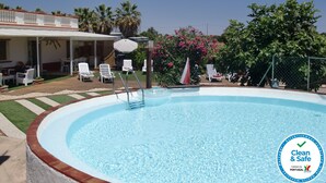 A swimming pool with lounge chairs and a covered patio area. - Villa Magaída, AC, private space with pool (Luz (Luz de Tavira))