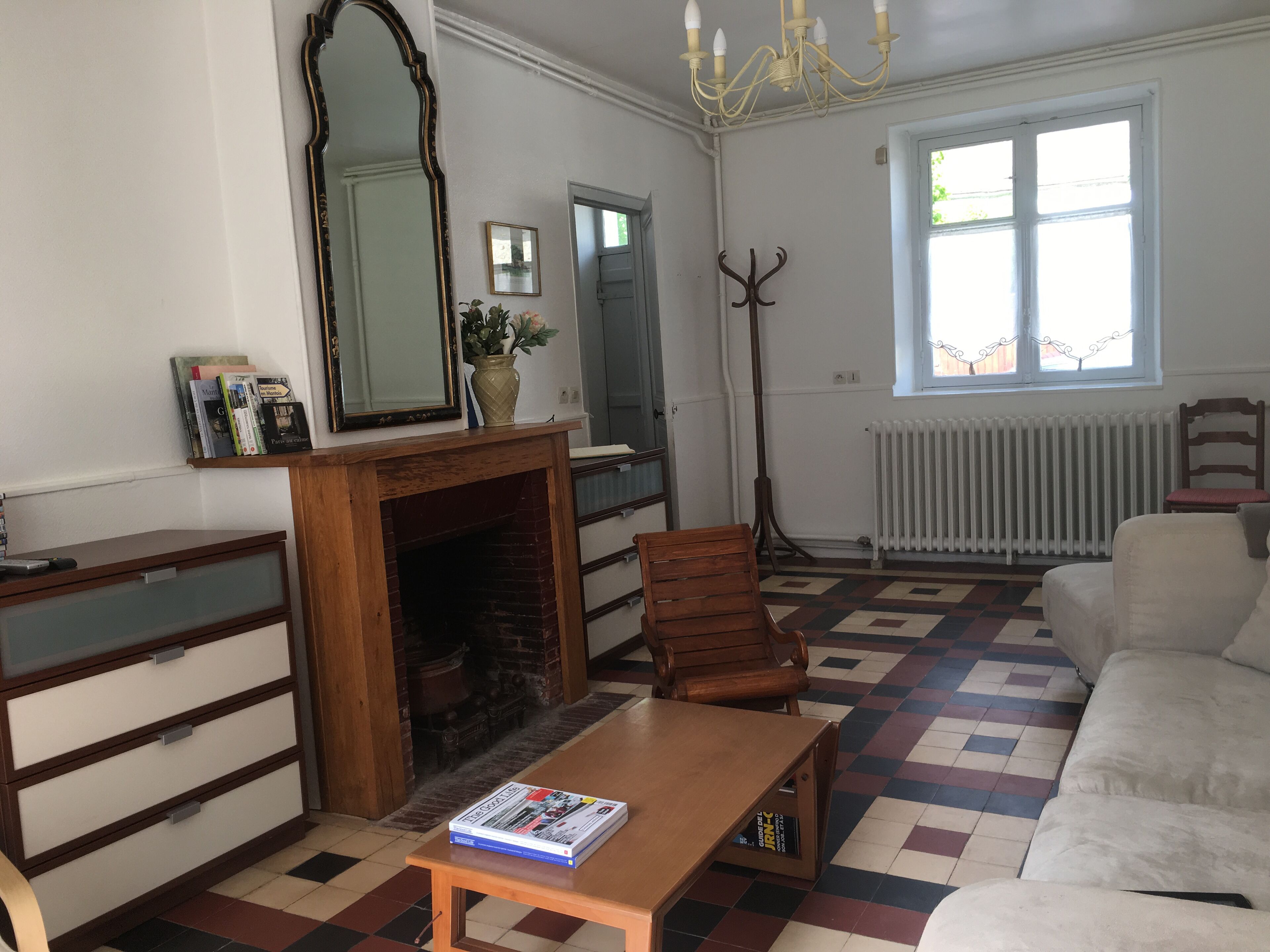 Un soggiorno con camino, un divano, un tavolo in legno e una libreria.