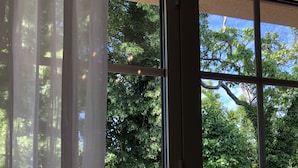 A window with a view of a grassy area and trees. - A charming stone house with unique views of the Dordogne River (Bergerac)