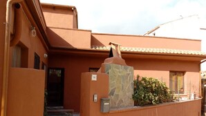 A building with a stone facade, a number '34' sign, and a small garden area with potted plants. - Large and quiet detached house in the historic center - CIN IT091095C2000S3477 (Tortolì)