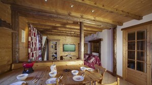 A wooden dining room with a wooden table set for four, surrounded by wooden chairs. - Lovely flat (sleeps 6/8) in chalet 300 m from slopes with shared sauna  (Les Avanchers-Valmorel)