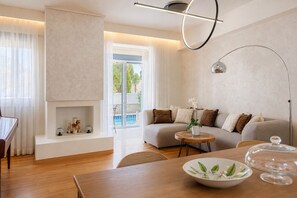 A modern living room with a sofa, a round wooden table, and a floor lamp.
