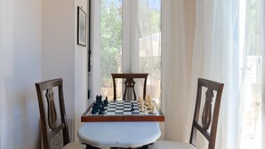 A table with a chessboard set up for a game, positioned between two chairs with decorative backrests. - Villa Kallergi - Nefeli (450 m2) House for 6, west-central Crete (Rethymnon)