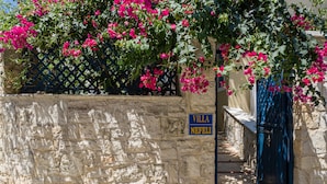 A stone wall with a sign reading "Villa Nefeli" and a blue gate. - Villa Kallergi - Nefeli (450 m2) House for 6, west-central Crete (Rethymnon)