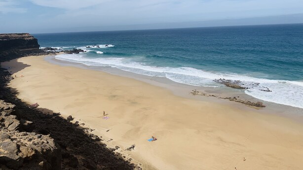 A beach with a rocky coastline and waves crashing onto the shore. - Apartment with WIFI  in a beatiful complex (Corralejo)