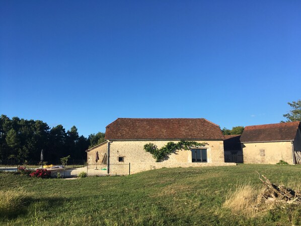 A rustic building with a sloped roof, a small window, and a door.
