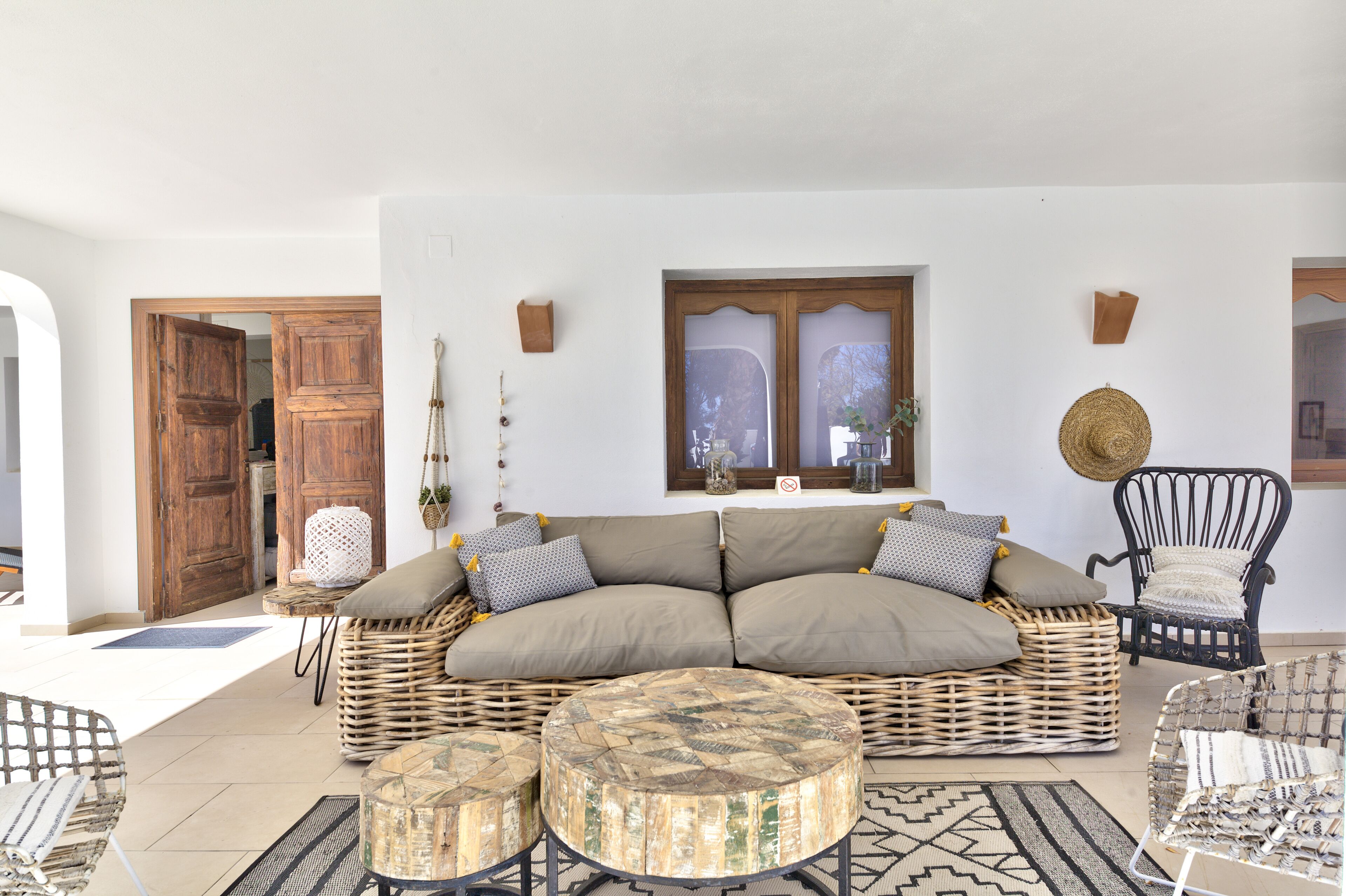 A living room with a sectional sofa, wicker furniture, and a round coffee table.