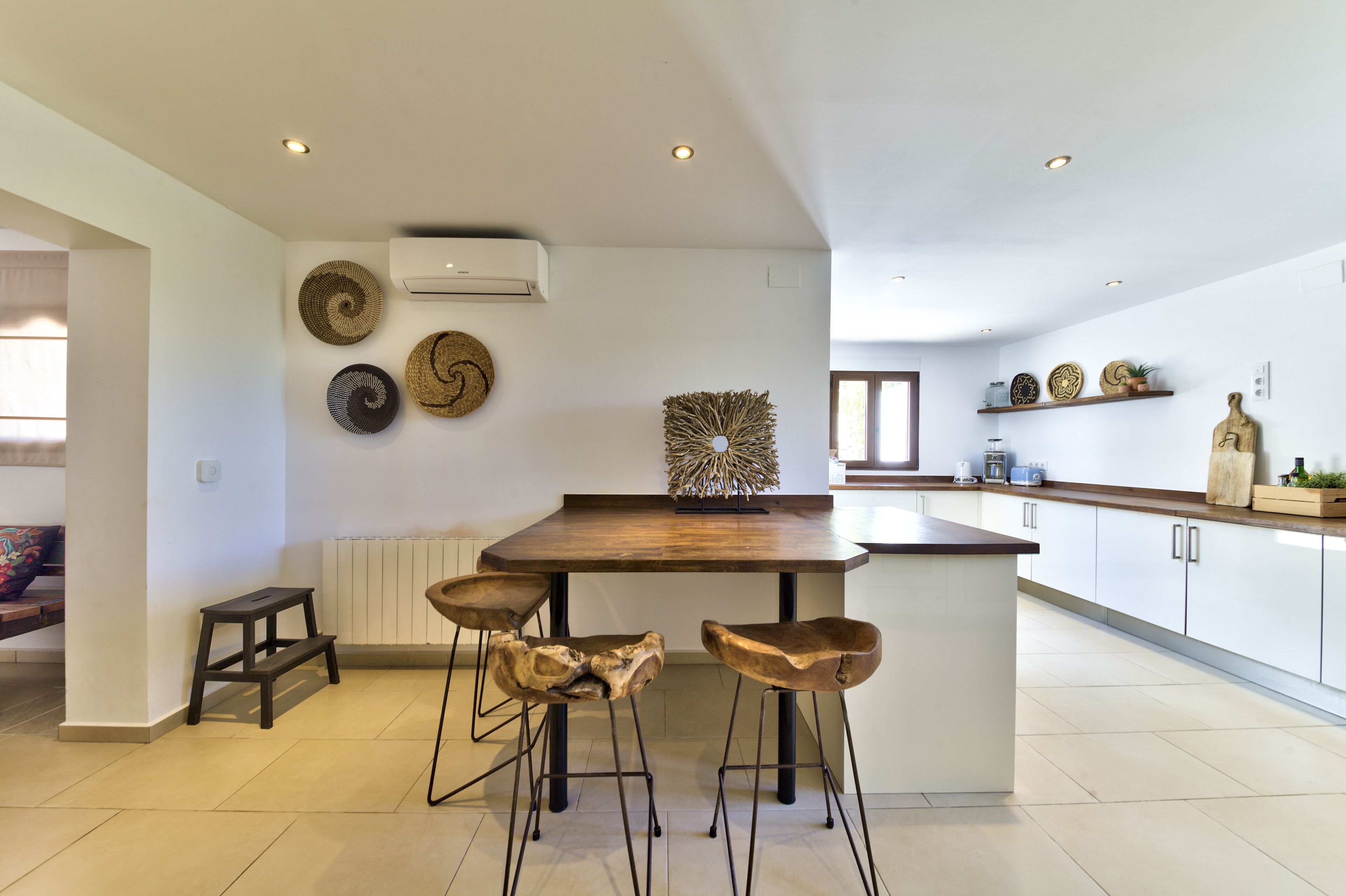 A modern kitchen with a central island, bar stools, and decorative wall art.