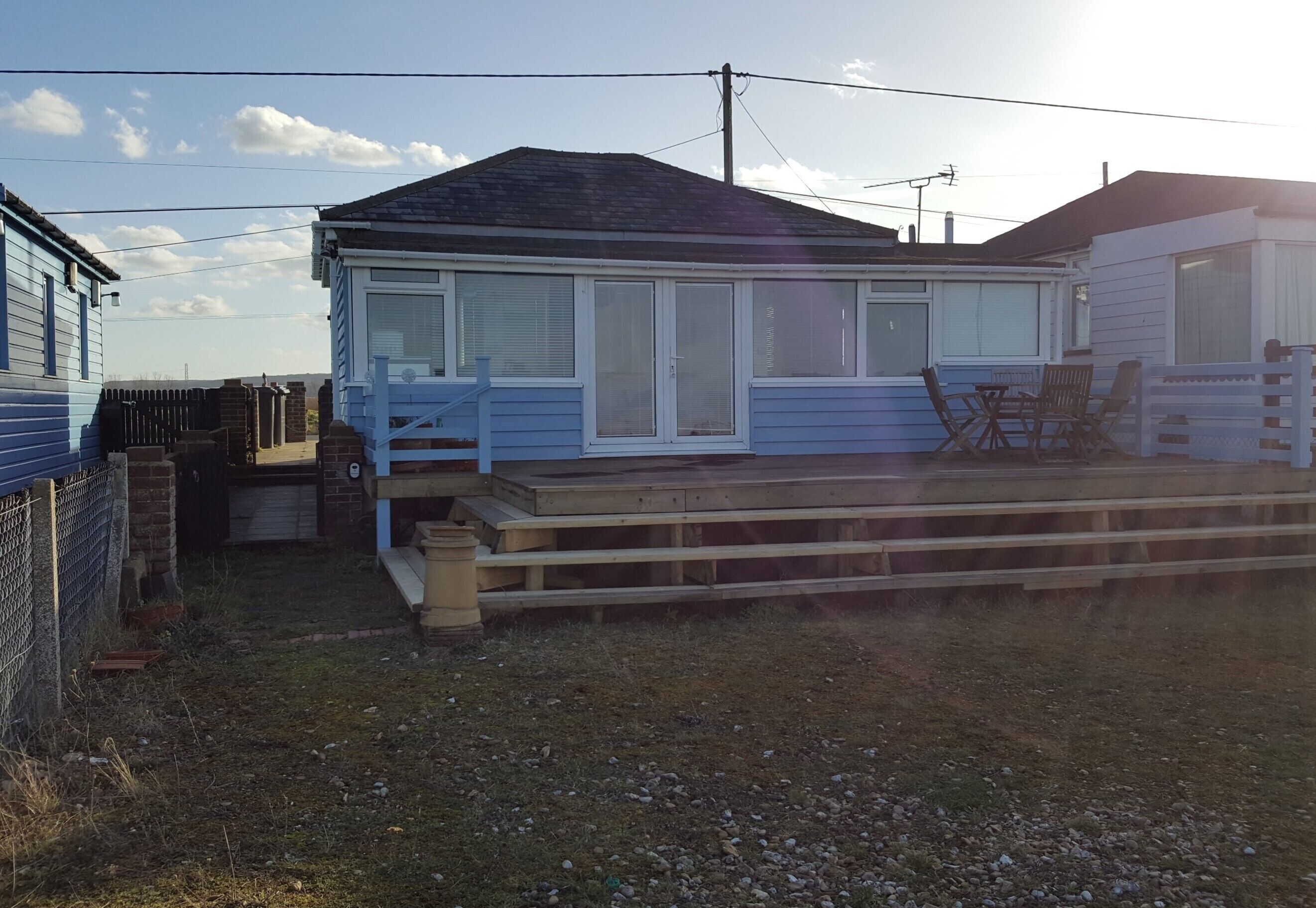 A single-story house with a front deck and a covered patio area.