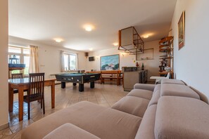 A living room with a pool table, a sofa, and a dining area with chairs. - Villa Elder ZadarVillas (Lepuri)