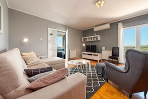 A modern living room with a sofa, armchair, coffee table, and a TV. - Villa Elder ZadarVillas (Lepuri)