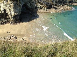 A coastal landscape with a sandy beach, rocky cliffs, and clear turquoise water. - Self Catering Rural Farm Cottage + Heated Pool Cornwall  (Launceston)
