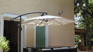 An outdoor patio with a table and chairs, a large umbrella, and a pergola structure. - Villa With Pool In St Paul En Foret, Nr Fayence, Cote D'azur-Provence, France (Saint-Paul-En-Forêt)