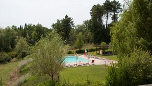 En baghave med swimmingpool, liggestole og et pergola.