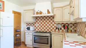 A kitchen with white cabinets, a microwave, a stove, and an oven.