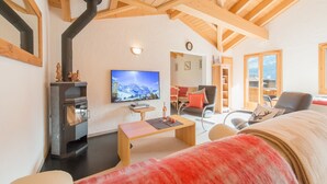 A cozy living room with a fireplace, a television, and a view of the outdoors.