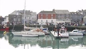 A marina with several boats docked, surrounded by buildings with traditional architecture. - Lobster Pot in Padstow Is A 'fisherman's Style' Cottage With A Parking Space. (Padstow)