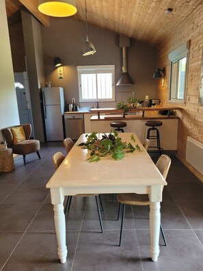 Een moderne keuken met een centraal eiland, een eettafel en barstoelen.
