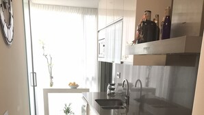 A modern kitchen with stainless steel appliances, a double sink, and a built-in oven. - BALMINS APARTMENT, FULLY EQUIPPED 50 MTS FROM THE BEACH OF ST.SEBASTIA (SITGES)