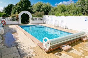 Una piscina al aire libre, una piscina climatizada