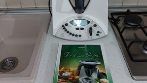 A kitchen with a food processor, a cookbook, and a tiled backsplash. - Sa Domu De Sa Murta 1B: 200 mtr to Baia Marina!!! Free Bikes & Kayaks. IUN P2964 (Torre di Bari)