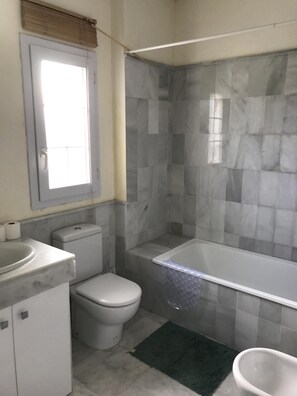 Tina con regadera, bidet, toallas, jabón 