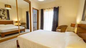 A hotel room with a large bed, a chair, a desk, and a mirror. - Casa Mateus (Alvor)