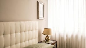 A neatly made bed with a headboard, a bedside lamp, and a framed picture on the wall. - The best choice for your vacation in Venice! (Venezia)