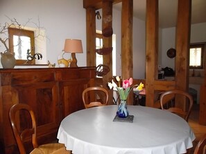 Enjoy meals in this charming dining area with a round table, vase, and comfortable seating.