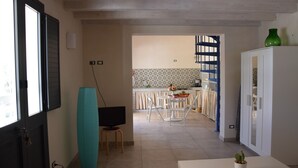 A kitchen with a dining area, a television, and a cabinet. - Vendicari time, just steps away from the calamus beaches and vendors (NOTO)