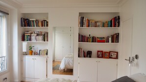 A bedroom with a bed, a bookshelf, and a wardrobe. - Charm and garden view, in the center of Paris, near Montparnasse (Paris)