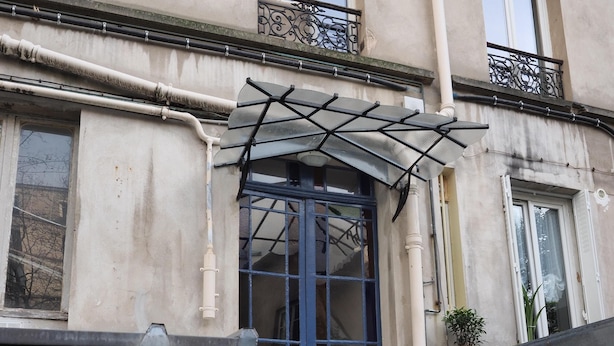 A building with a blue door, white walls, and a small balcony with a metal railing. - Charm and garden view, in the center of Paris, near Montparnasse (Paris)