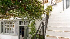 Un bâtiment aux murs blanchis à la chaux, avec un escalier menant à une porte.